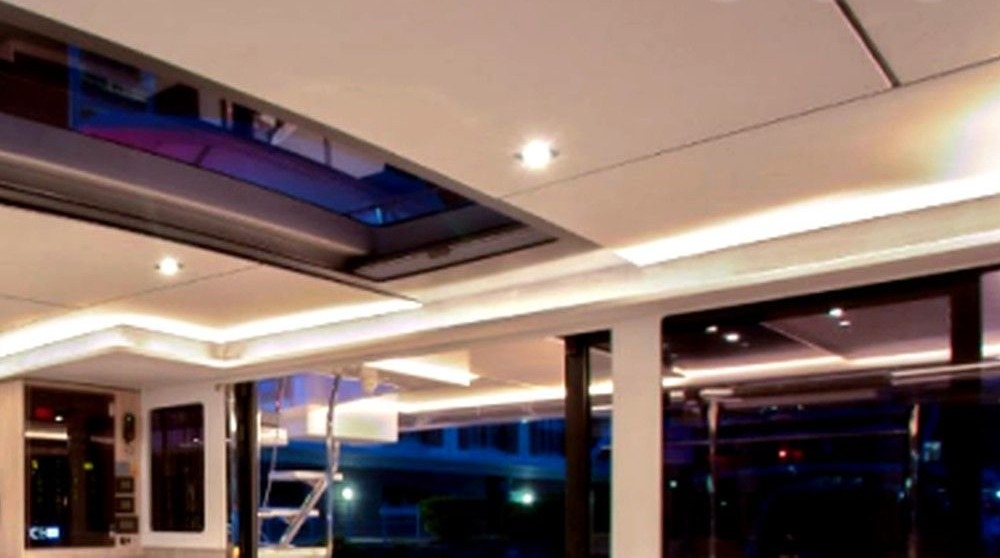 Night saloon looking aft with warm LED cove lighting and open doors
